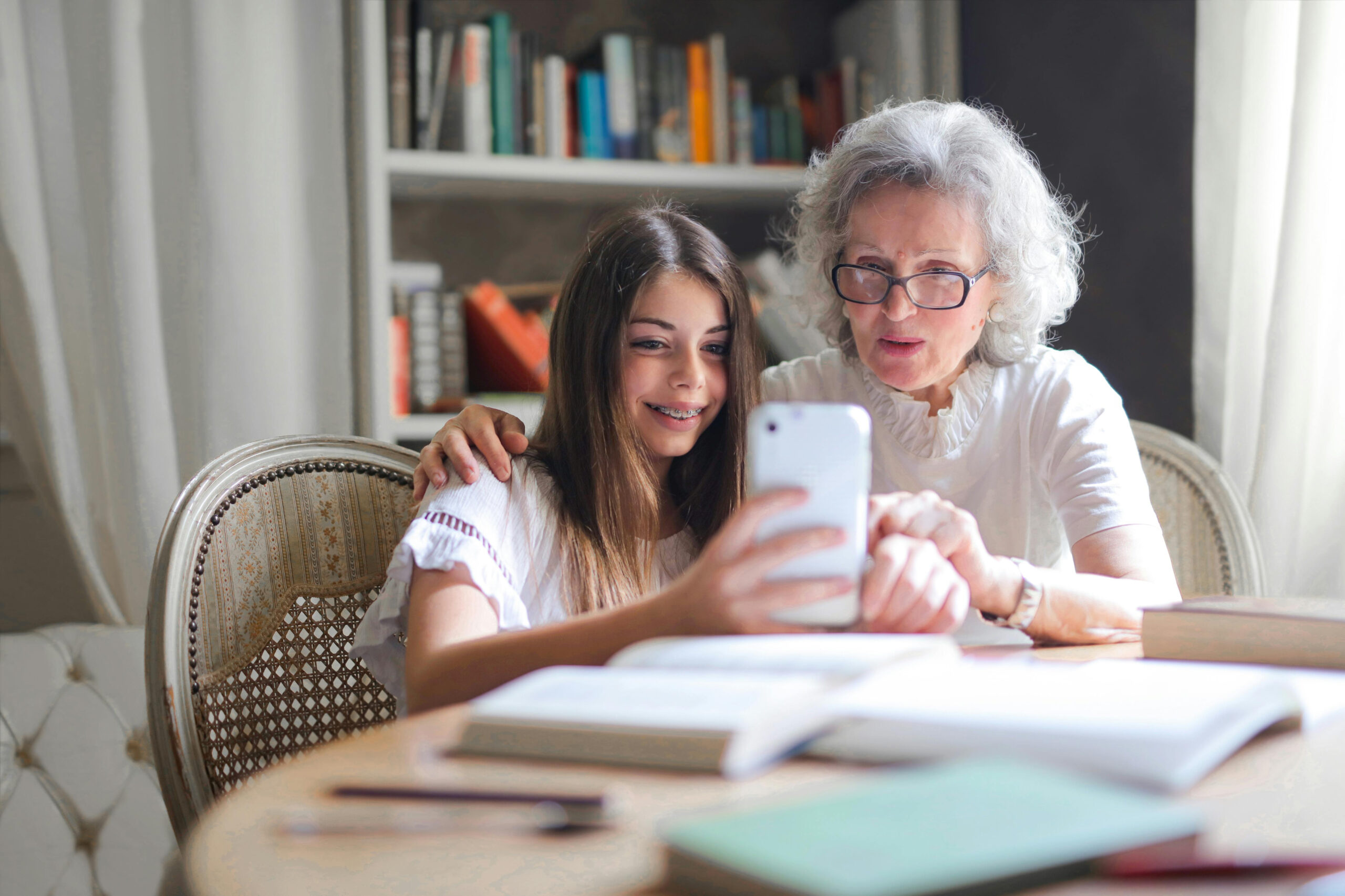 A grand daughter and grandmother looking at photographs